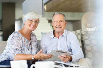 Older couple reading clipboard on sofa