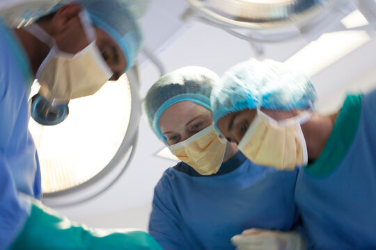 Surgeons bent over patient in operating room
