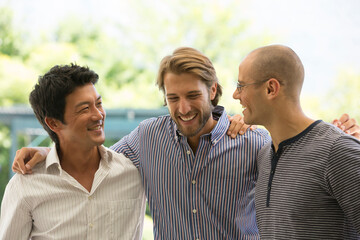 Smiling men talking outdoors