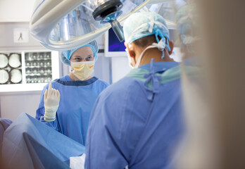 Surgeons standing over patient in operating room