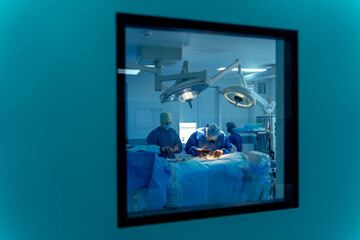 Group of surgeons in operating room with neurosurgery equipment. Medical background, selective focus.