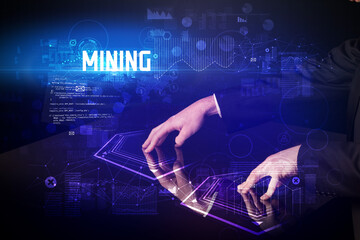 Hand touching digital table with MINING inscription, new age security concept