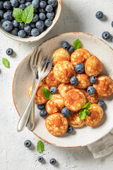 Homemade poffertjes with fresh berries and mint leaves