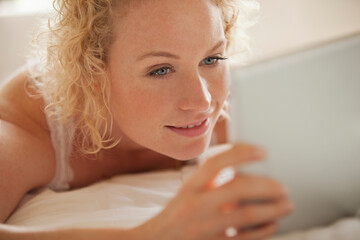 Close up of woman using digital tablet in bed