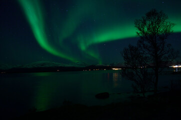 Naklejka na ściany i meble fantastic strong aurora borealis over cold fjord and mountain