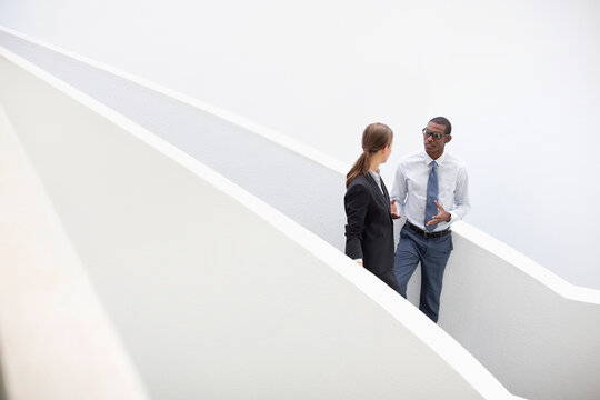 Businessman and businesswoman talking on modern staircase