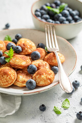 Homemade mini pancakes with blueberries and mint leaves