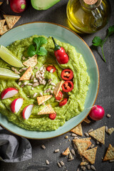 Traditional guacamole served with crackers, coriander and sunflower seeds