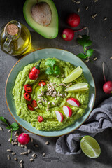 Vegan guacamole served with radish, crackers and lime
