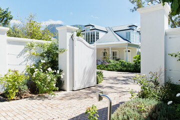 Driveway with open gate to luxury house