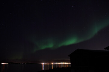 Fototapeta na wymiar aurora borealis over cold fjord and mountain in autumn