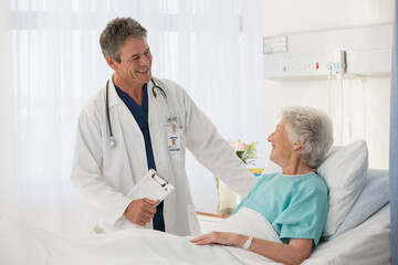 Doctor talking to elderly patient in hospital