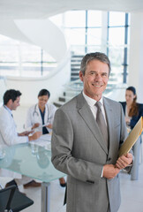 Portrait of smiling businessman in meeting with doctors