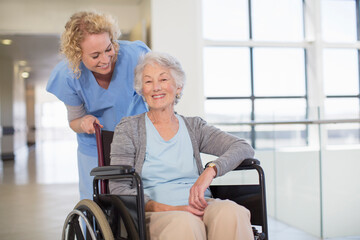 Fototapeta na wymiar Nurse and aging patient smiling in hospital corridor