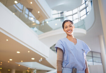 Portrait of smiling nurse in hospital atrium - Powered by Adobe
