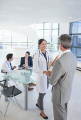 Doctor and businessman shaking hands in meeting