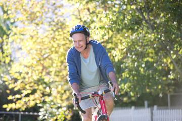 Naklejka premium Senior man riding bicycle in park