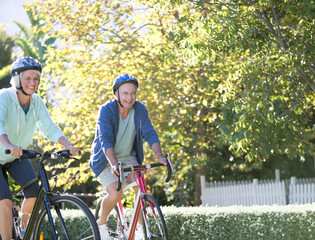 Senior couple riding bicycles in park