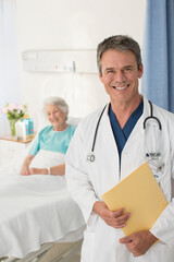 Portrait of smiling doctor with patient in background