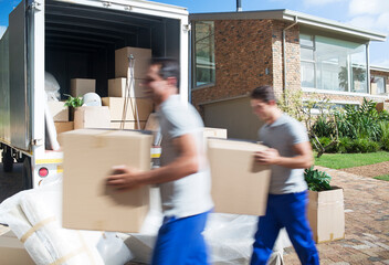 Movers carrying cardboard boxes in driveway past moving van - obrazy, fototapety, plakaty