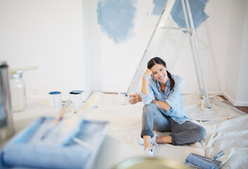 Portrait of woman surrounded by paint supplies