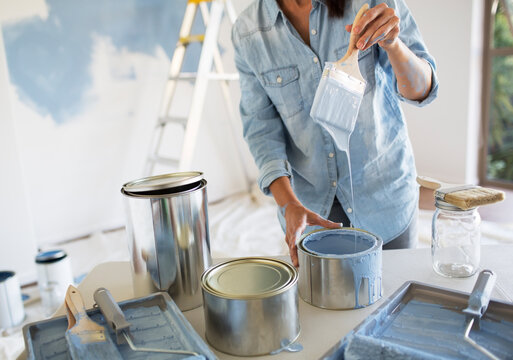 Woman holding paintbrush with blue paint