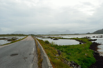 long road through sea water and mountain landscape, vesteraalen Norway