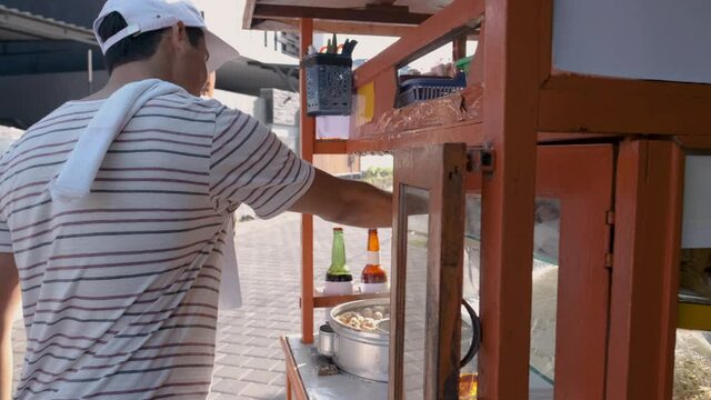 man selling bakso in the carts. indonesia street food vendor. small business entrepreneur