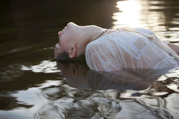 Woman leaning head back in river