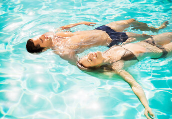 Couple floating in swimming pool