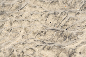 An abstract pattern in sand on the beach caused by waves.