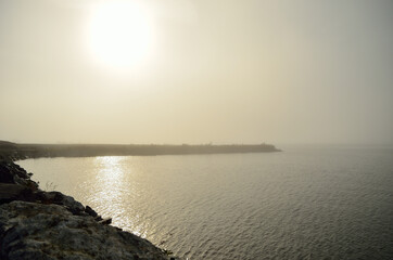 sun over pier shrouded in fog and mist in autumn