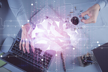 Double exposure of man's hands typing over computer keyboard and brain hologram drawing. Top view. Ai and data technology concept.