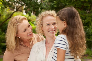 Fototapeta premium Three generations of women smiling outdoors