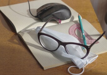 On the notebook is a medical mask, glasses, protractor, pen. Concept - protection from coronavirus,...