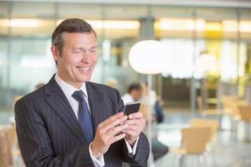 Fototapeta na wymiar Businessman using cell phone in office