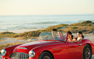 Family in convertible on beach