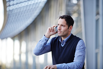 Businessman talking on cell phone outdoors