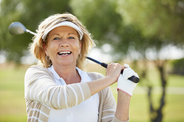 Senior woman playing golf on course - Powered by Adobe