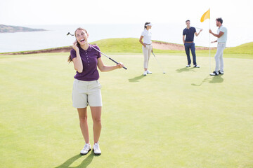 Woman talking on cell phone on golf course