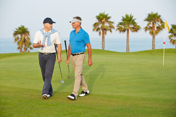 Senior men walking on golf course