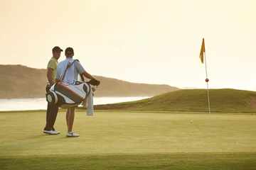 Gordijnen Men on golf course overlooking ocean © Chris Ryan/KOTO