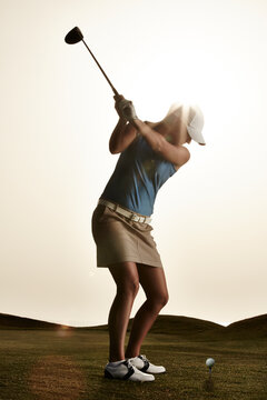 Woman Swinging Golf Club