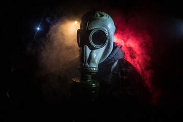 Gas mask with clouds of smoke on a dark background. Sign of radioactive contamination. Means for...