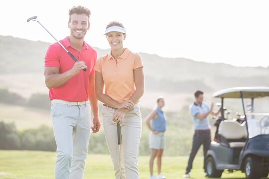 Smiling couple on golf course - Powered by Adobe