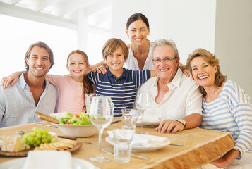Multi-generation family smiling together at table