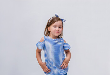 A beautiful little girl in a striped blouse and headband on a white isolated background with space for text.