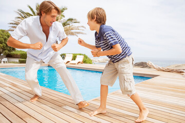 Father and son playing by pool