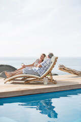 Older couple relaxing by pool