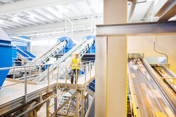 Worker on platform in recycling center